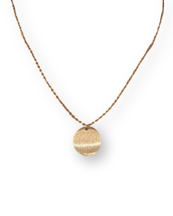 Gold necklace with a round pendant on a white background